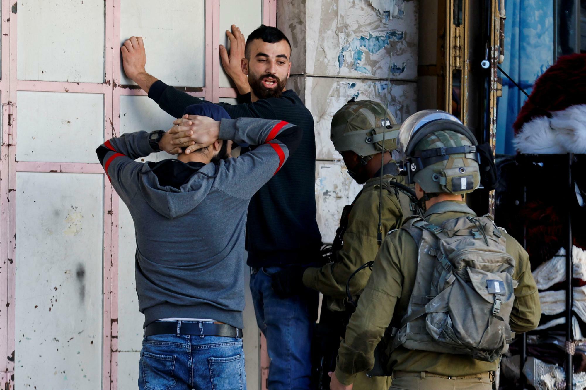 イスラエルが占領するヨルダン川西岸のヘブロンでパレスチナ人の身体検査をするイスラエル兵（2022.11.19）。先進国は占領を批判するものの、これに抵抗するパレスチナ人を「テロリスト」と呼んできた。