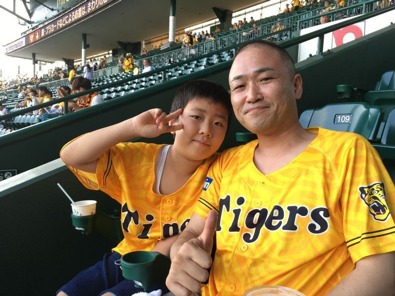 大阪出身の古家四段。お子さんと野球観戦中(本人提供)。
