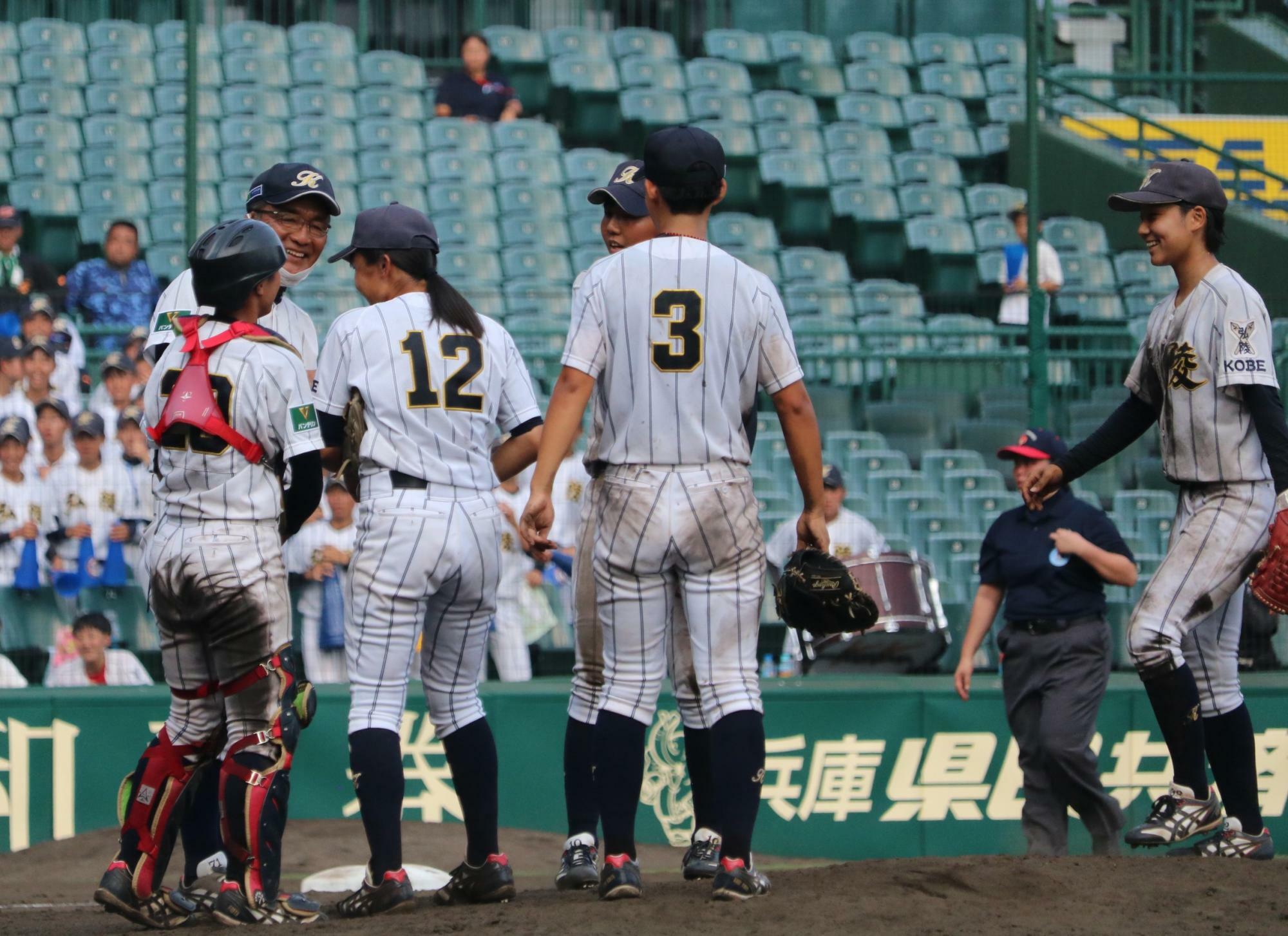 投手交代を告げ笑顔でマウンドへ歩み寄った神戸弘陵・石原康司監督