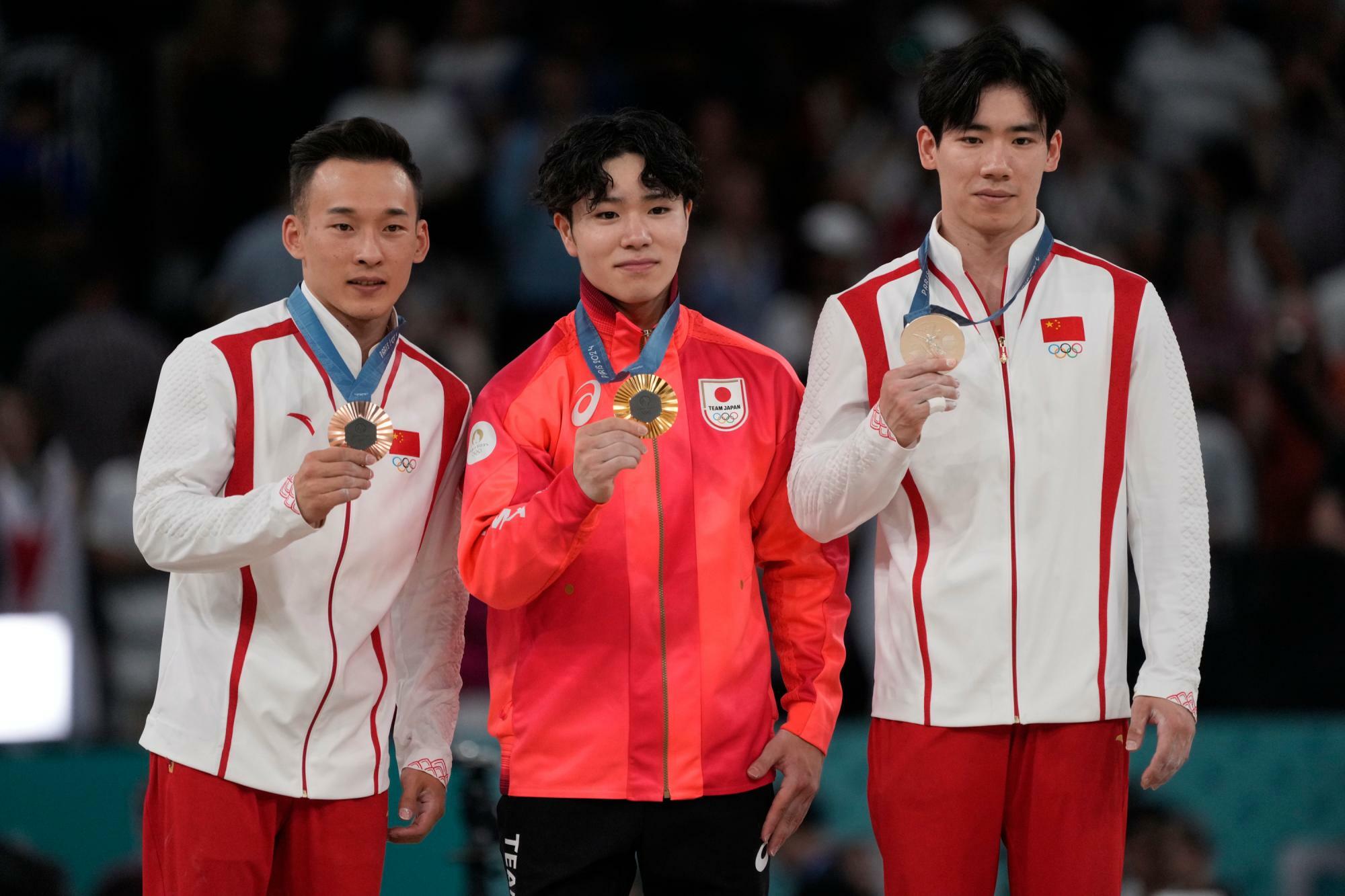 体操男子個人総合で金メダルに輝いた岡慎之助選手（中央）と中国の張博恒選手、肖若騰選手