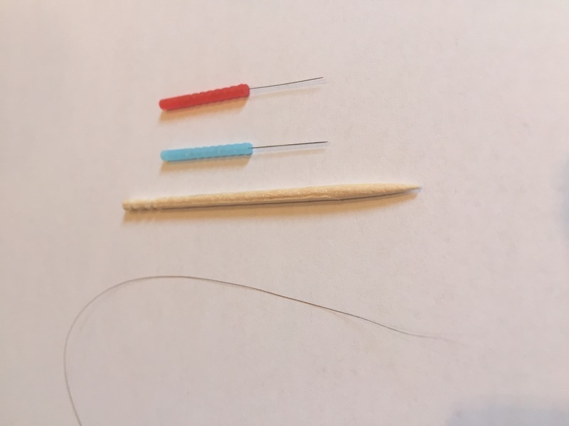 赤と青の先端部分が顔に刺したハリ。一番下の髪の毛くらい細いのがわかる。