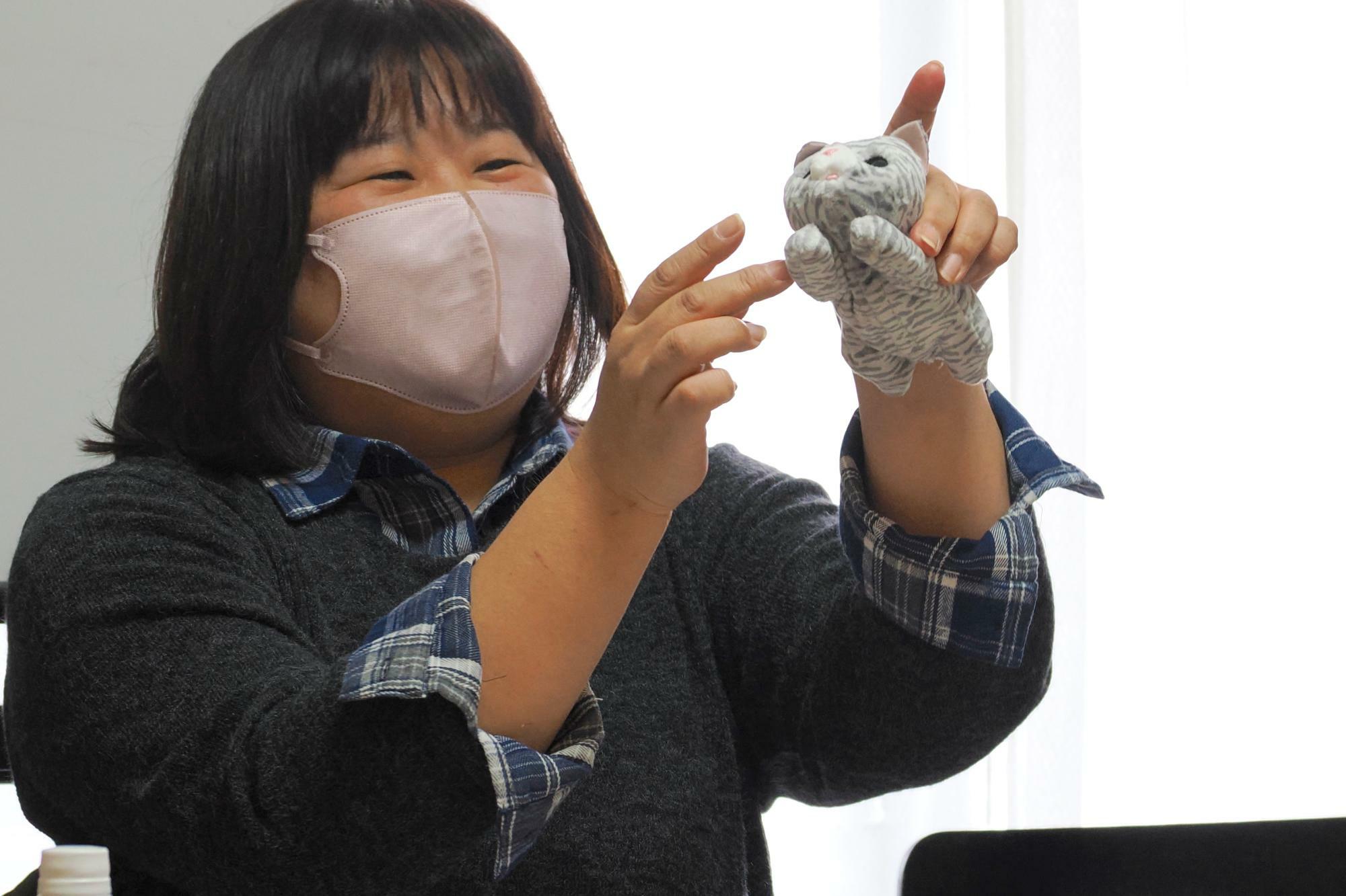 「那珂川ねこネットワーク」の小林綾子さん。ぬいぐるみを用いて離乳食を与える方法を伝授。（筆者撮影）