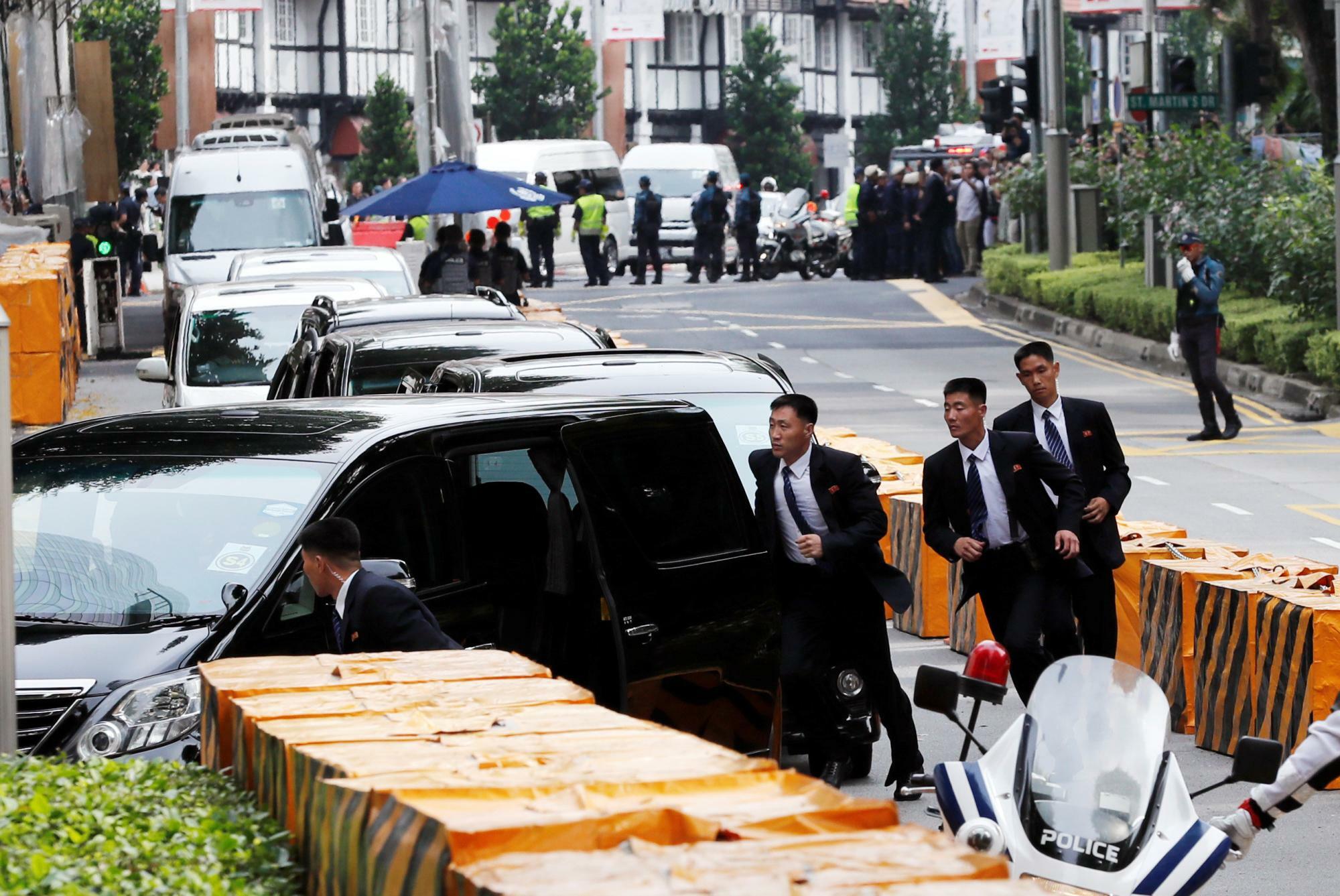 2018年6月10日、シンガポールで北朝鮮の金正恩総書記を乗せた車と並走する北朝鮮の警備要員