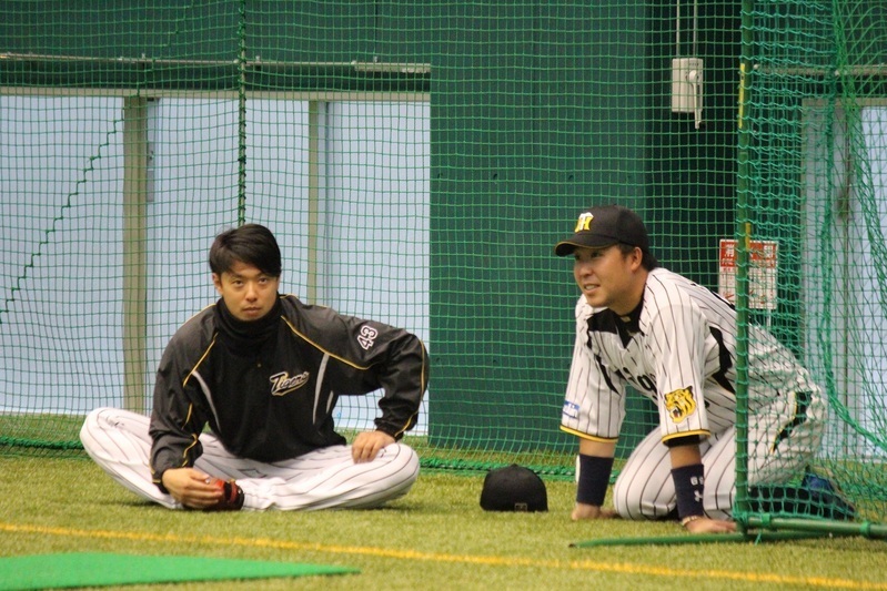 入念にストレッチをする西村投手(左)のそばへ行く森田選手。