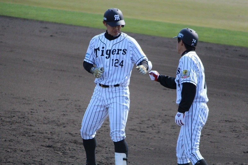 原口選手(左)は25日に今季初安打を放ち、一塁で藤本コーチとグータッチ。