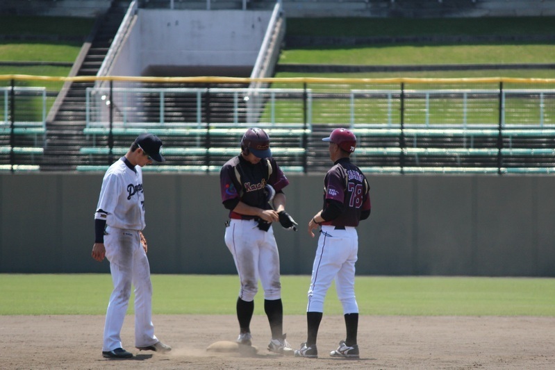 二塁打を放った藤井選手（左）のレガースなどを受け取るのも三塁コーチの河埜監督。