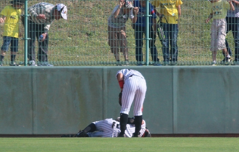 9回、打球を捕ってフェンスにぶつかって倒れた江越選手。心配する緒方選手とお客様。