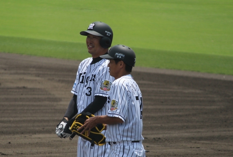 1回の第1打席で左前打を放った関本選手(左)。一塁上で藤本コーチと笑顔です。