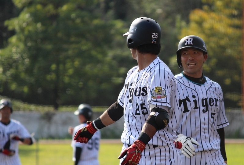 勝ち越しのホームを踏んだ伊藤隼選手(右)を迎え、殊勲の中谷選手を見やる江越選手。