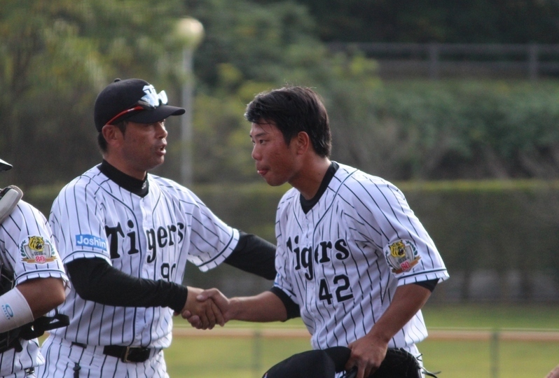 26日の最終戦、投げ終わってベンチ前で香田投手コーチとガッチリ握手。