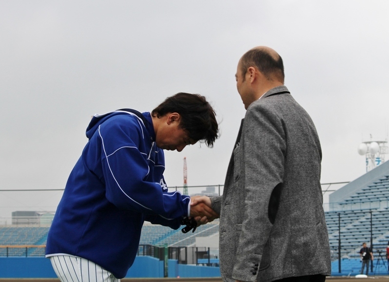 視察に訪れた石川の佐野滋紀取締役(右)と握手を交わす西村投手。