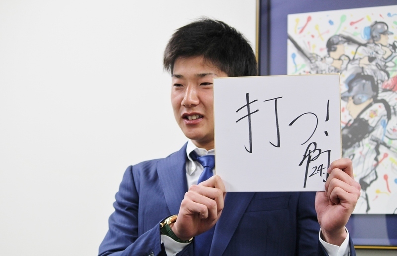 書いたばかりの色紙を掲げて、笑顔で撮影に応じる横田選手です。