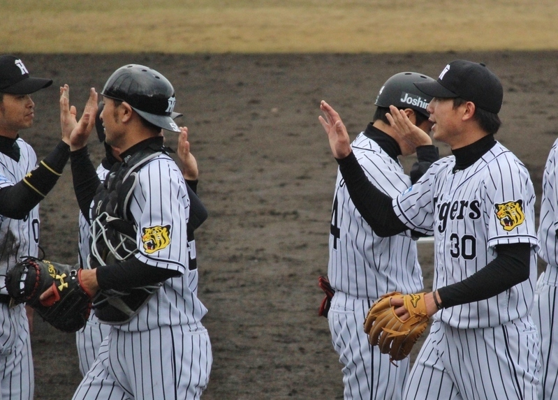 三者凡退で試合終了。ハイタッチをする石崎投手(右)と小豆畑選手(左)。