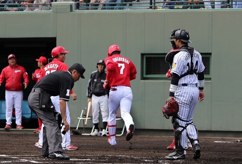 秋山投手からホームランを打った堂林選手(背番号7)を見送る原口選手(右)。
