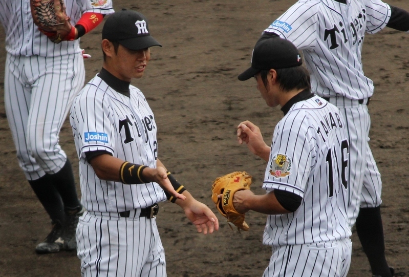 昨年9月、投げ終わった田面投手(右)を迎える原口選手。2人ともまだ3ケタでした。