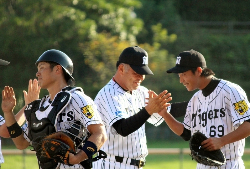 掛布監督(中)に迎えられる坂本選手(左)と島本投手。島本投手は…この苦笑いです。