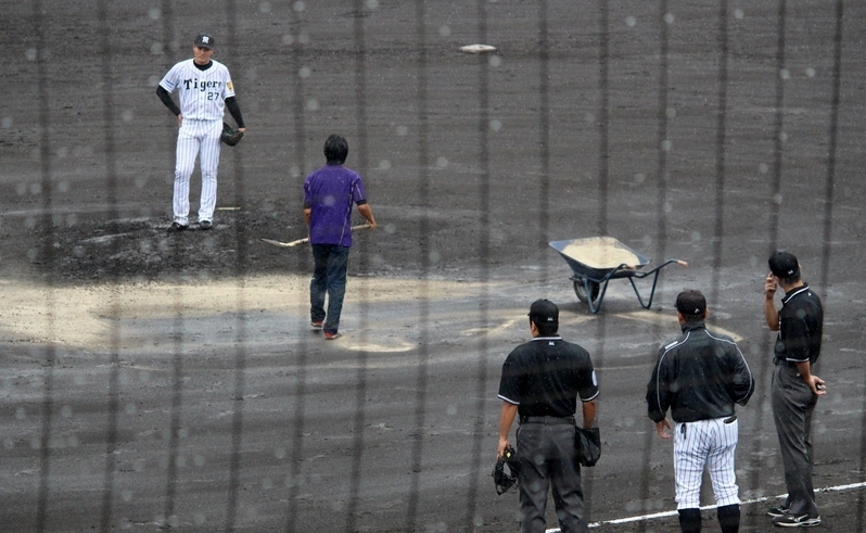 砂入れ作業。秋山投手(左)や久保投手コーチ、審判も見守ります。