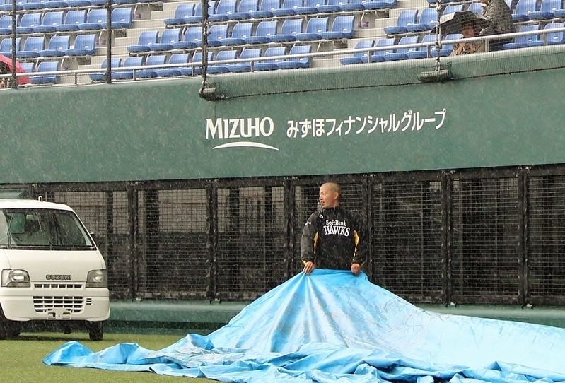 昨年3月30日のソフトバンク‐阪神戦は試合前に大雨…。シートを片付ける西山さん。
