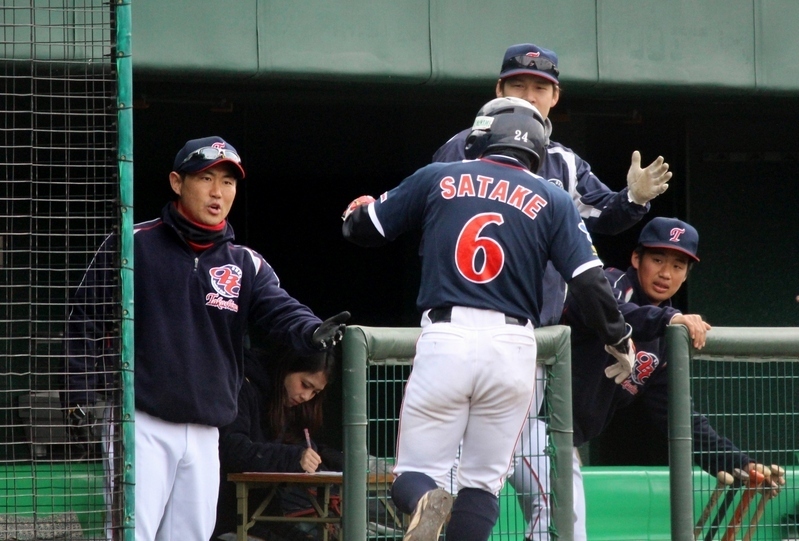 第1試合の1回、先制のホームを踏んだ佐竹選手を迎える野原監督(左)。