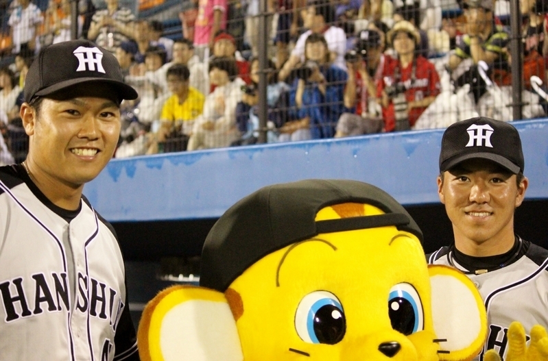 福永投手(左)と、キー太を挟んで記念撮影中の長坂選手。
