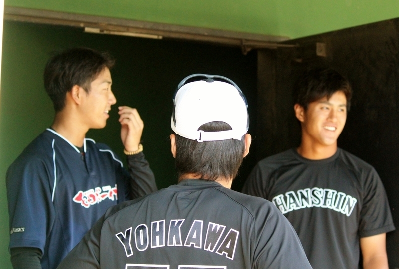 ベンチで談笑中。岩本投手(左)、陽川選手(背中)、板山選手。