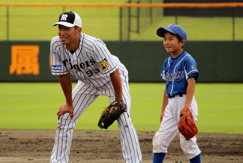 少年と並んで、ノックの打球を待つ西田選手。