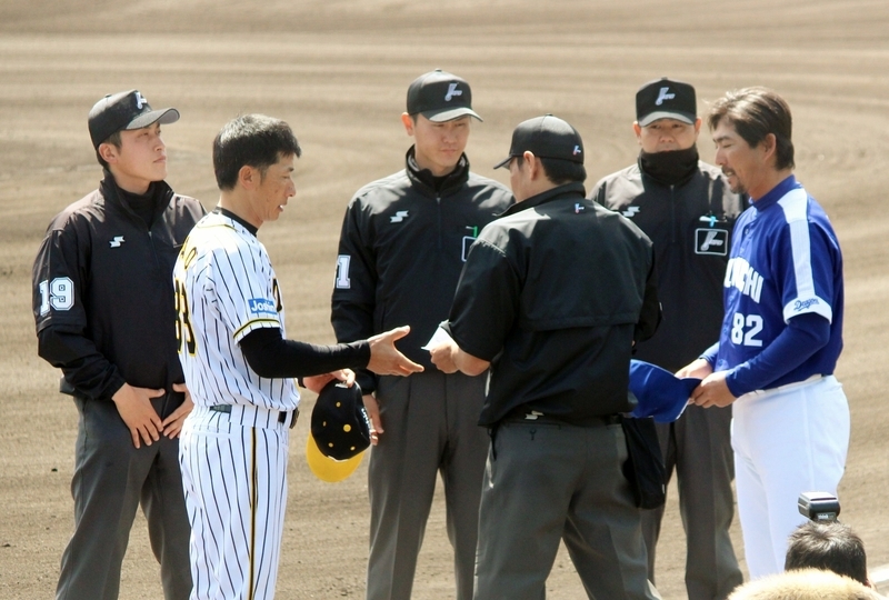 試合開始前、メンバー表の交換をする矢野、小笠原両監督と審判団。