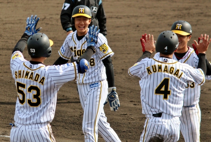 生還した熊谷選手が板山選手とハイタッチ(右の2人)。代走だった小幡選手と迎える島田選手(左の2人)。