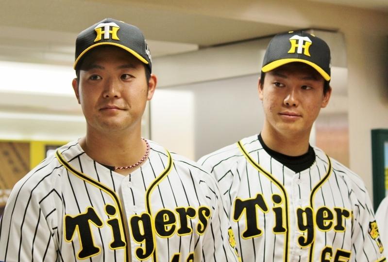 写真は31日、開門時にお客様を迎える斎藤投手(左)と湯浅投手(右)。