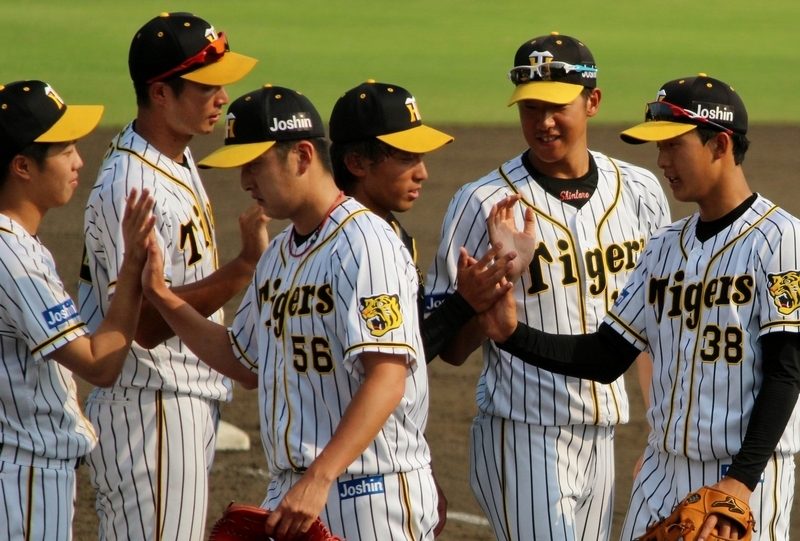 試合終了で呂投手(左)とタッチする飯田投手(左から3人目)。