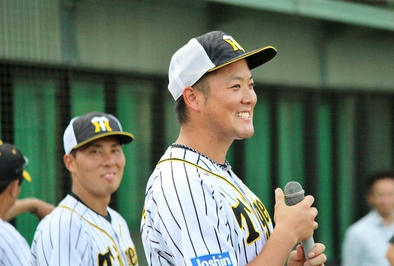 野球教室の閉会式でマイクを手に挨拶する斎藤投手。斜め後ろの笑顔は片山選手です。