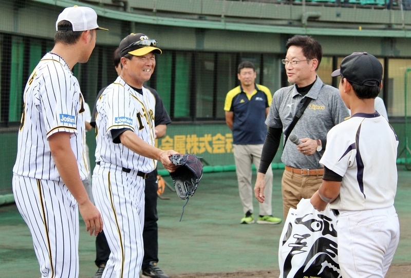 少年に、尾仲投手のグラブをプレゼントしようとする平田監督(左から2人目)。ものすごいニヤニヤ顔ですね！