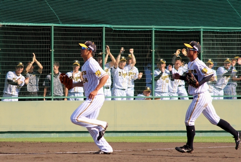 ベンチへ戻る横田選手(左)に拍手を送るのは、三塁ブルペンで試合を見ていた1軍メンバー。