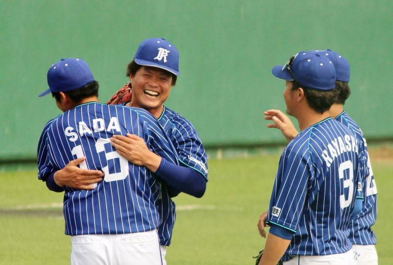 ※投球練習場で投げながら戦況を見守っていた守屋投手(左から2人目)も佐田健介投手と抱き合って、この笑顔！