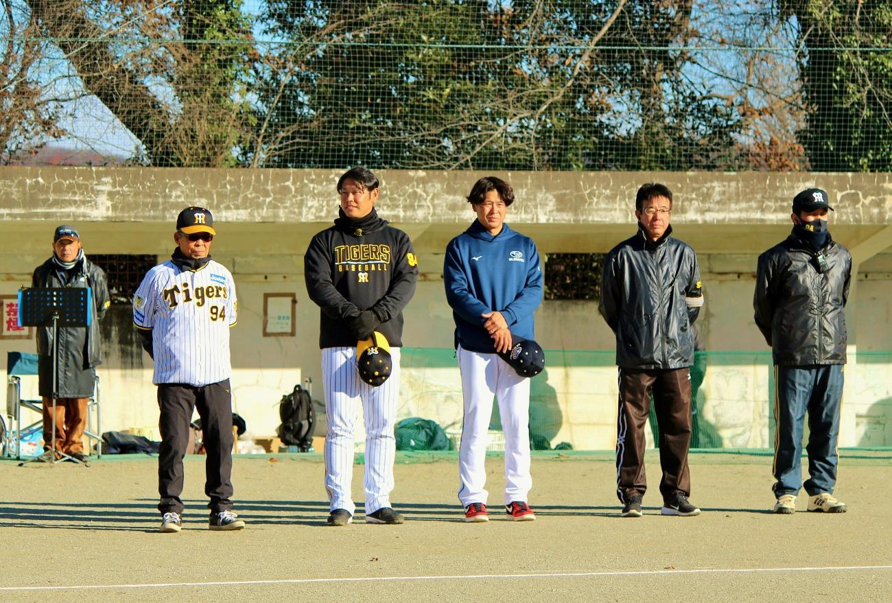 野球教室の開会式で整列する後援会役員の皆さんと原口選手、日置選手。