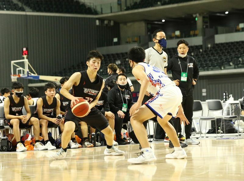 選手のプレーを見守る小倉貴誉HC（右） 写真提供:日本バスケットボール協会