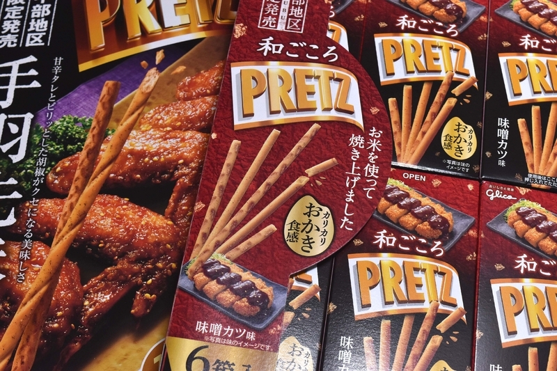 江崎グリコの「ジャイアントプリッツ手羽先味」は14袋入り、「和ごころプリッツ 味噌カツ味」は6箱入りとどちらもお土産向けのジャンボサイズパッケージ商品。いずれも中部地区限定販売