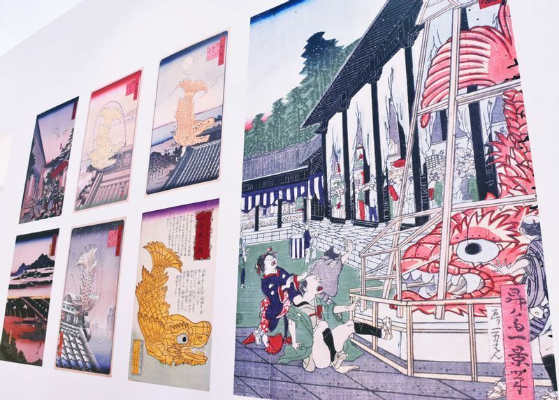 金鯱の大きさに驚く庶民など、錦絵などにも数々描かれてきた。写真は「名古屋城 金鯱展」のパネル展示