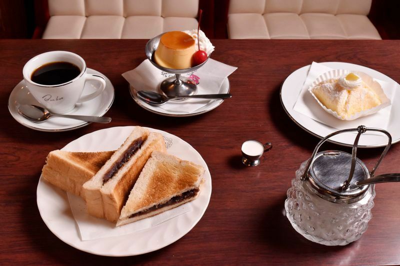「洋菓子　喫茶ボンボン」のブレンドコーヒー360円、アントースト450円、プリン320円、マロン300円。隣の洋菓子店では30種以上のケーキを販売し、喫茶でも食べられる