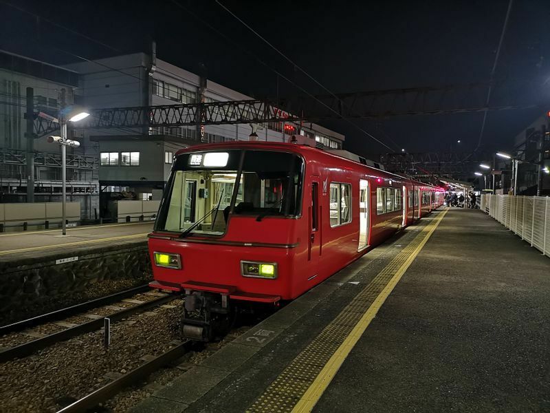 “赤い電車”として親しまれる名鉄電車が地元愛や郷愁を喚起するアイコンに。「名古屋行き最終列車」は、名古屋から周辺都市へ帰る多くの人の流れとは逆方向への移動を意味し、登場人物の心境や立場を暗示している