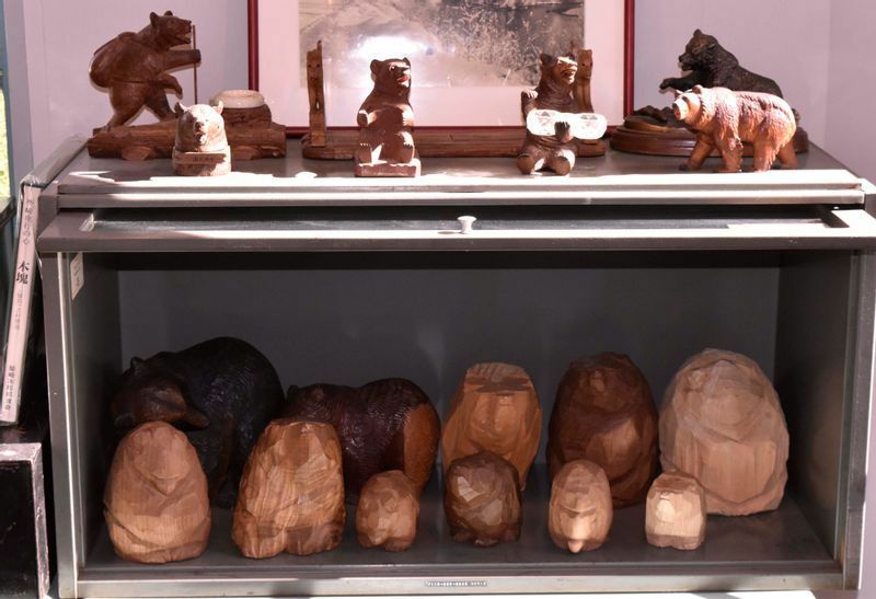 「COMPASS」店内にディスプレイされた木彫り熊。ケース内の柴崎作品の熊はすべて非売品だが、ケース上のスイスの木彫り熊は販売商品。価格は1万円前後～。