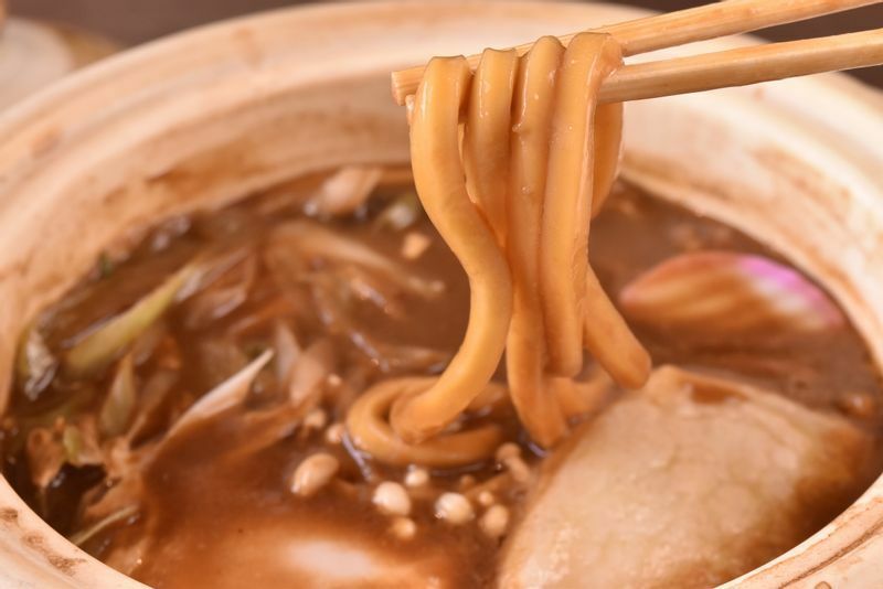 太めで噛み応えがある麺が名古屋のみそ煮込では主流。一般的なうどんと違って、塩水ではなく真水で生地をこねる。そのため土鍋で煮込んでそのままお客に提供できる