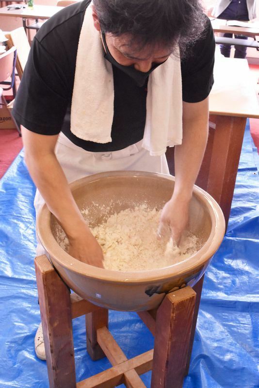 「角丸」店主・日比野宏紀さんによるきしめん手打ちの実演。「水まわし」と呼ばれる塩水と小麦粉を混ぜ合わせていく作業。「粉ひと粒ひと粒に塩を混ぜていくイメージ。ここが一番大事」と日比野さん