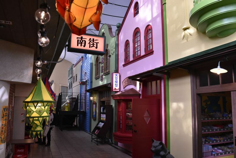 懐かしくもちょっと怪しげなムードも漂う昭和の商店街のような「南街」（みなみまち）。駄菓子屋、模型屋、本屋が軒を連ね、並んでいる商品は実際に購入できる