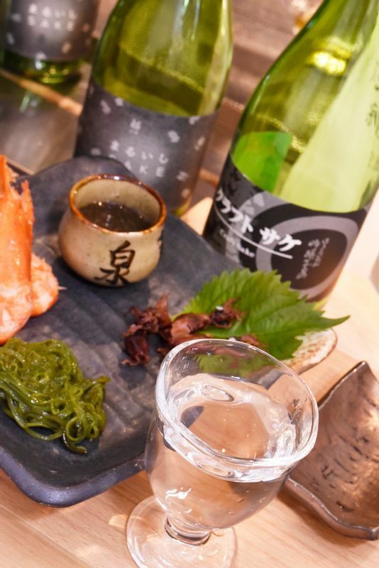 日本酒は写真の45mlが330円～、90ml550円～。つまみは愛知・岐阜・三重の魚介、味噌、缶詰などを使ったものなどが10種以上で200～500円台