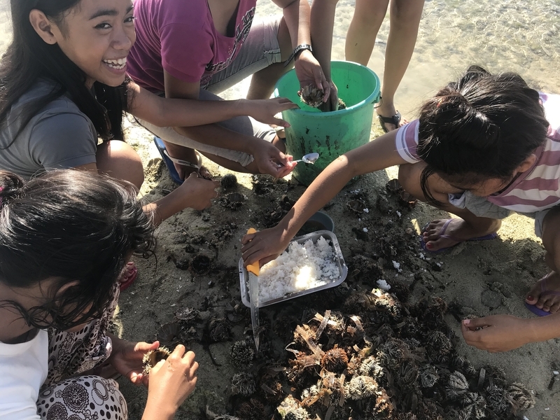 カオハガンの子どもたちのおやつ。目の前の海でとったウニをごはんにのせてパクリ(著者撮影)