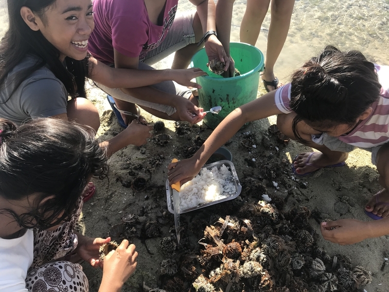 カオハガンの子どもたちのおやつ。目の前の海でとったウニをごはんにのせてパクリ（著者撮影）