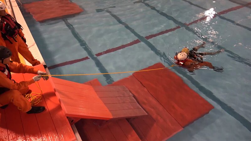 図2(c) 未浸水部にいる人がロープで引っ張り近づける（水難学会提供）。一連の技術は、施設内が浸水し、逃げ遅れた人を緊急的に移動させることを想定しています。