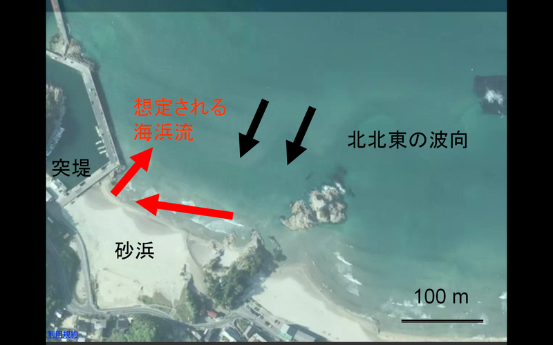 図2 鳥取県小栗浜海岸の上空写真。黒の矢印が事故当日の波向で、赤の矢印は想定される海浜流。突堤に沿って沖に流れるのが離岸流（Yahoo!地図をもとに筆者作成）