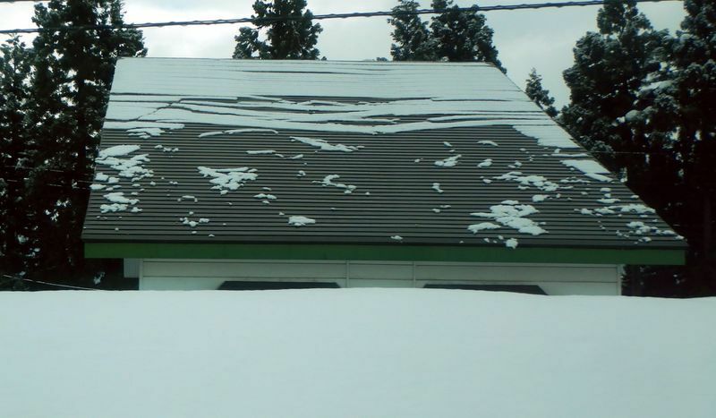 図5 落雪式屋根からの落雪の様子。ある程度まとまって流れるようにして新雪が落ちてくる（筆者撮影）
